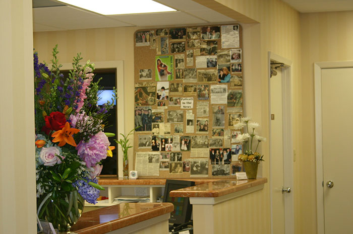 Corkboard of photos and newspaper clippings on wall