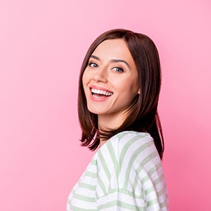 Woman with beautiful smile standing against pink background