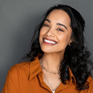 Smiling woman in orange collared shirt