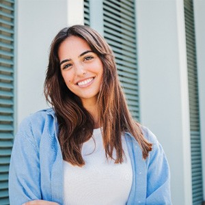 Woman with white teeth smiling while standing outside