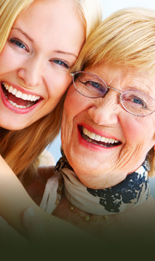 Elderly woman smiling with young woman after gum disease treatment in North Dallas