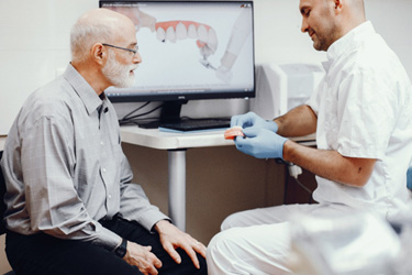 Dentist showing patient model of teeth