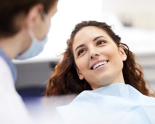 a patient smiling while visiting her dentist