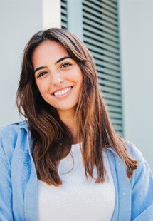 Woman with white teeth smiling while standing outside