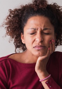 Woman with toothache sitting on couch at home