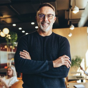 a smiling man with his arms crossed