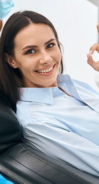 patient smiling and giving an okay sign with her hand