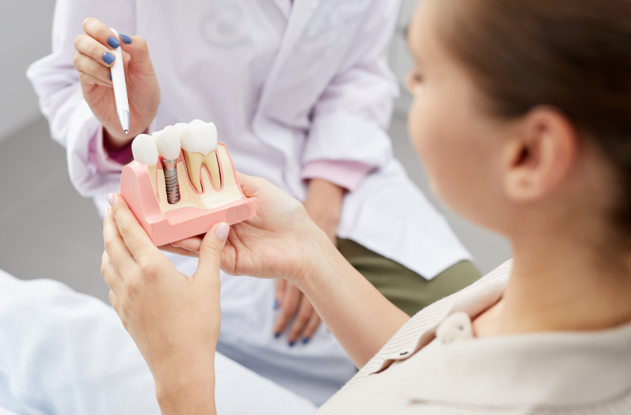 Dentist showing patient dental implant model